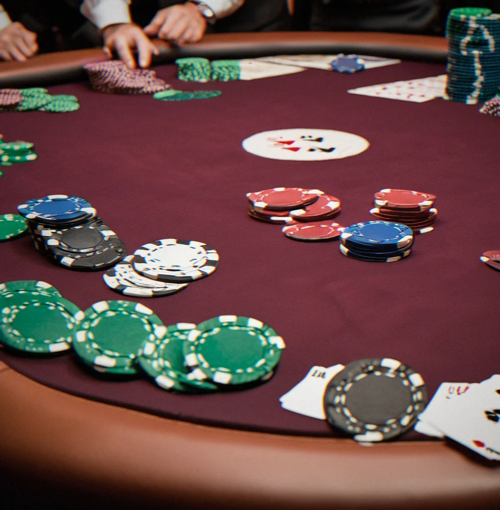 Tournament poker table with felt and stacked clay chips at a corporate event